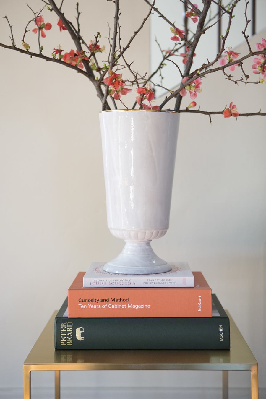 White urn filled with cherry blossom branches