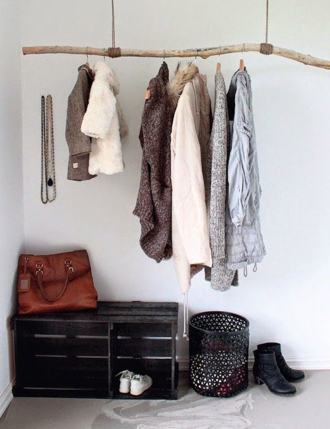 Large branch tied with rope to the ceiling for a clothing rack