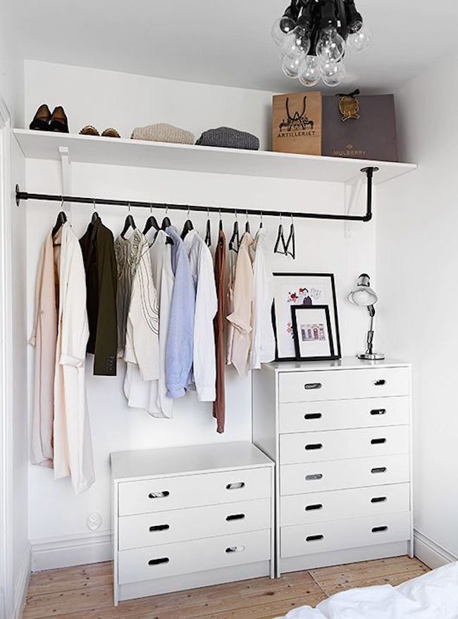 Minimalist open concept closet with white dressers