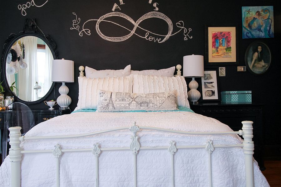 An all-white bed sits in front of a black chalkboard wall in the small bedroom [From: Michaela Dodd]