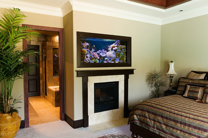 Aquarium above fireplace in bedroom