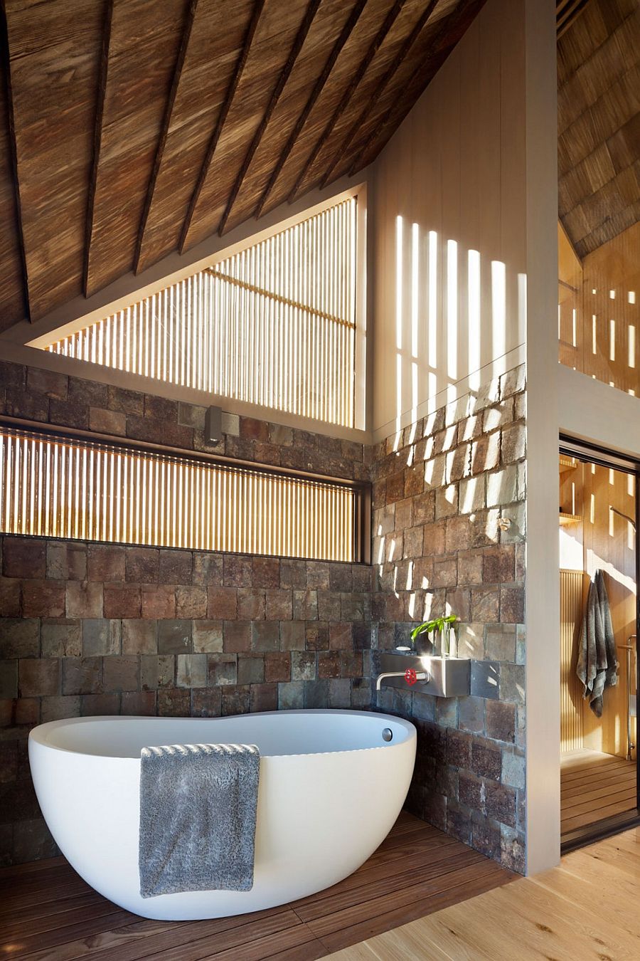 Bathroom with stone walls and freestanding bathtub