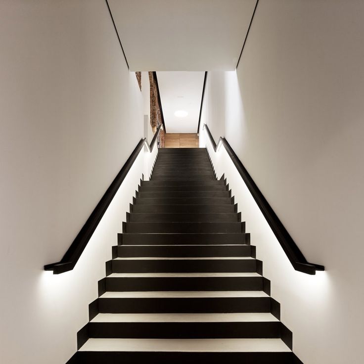 Black and white staircase with lighting along railings