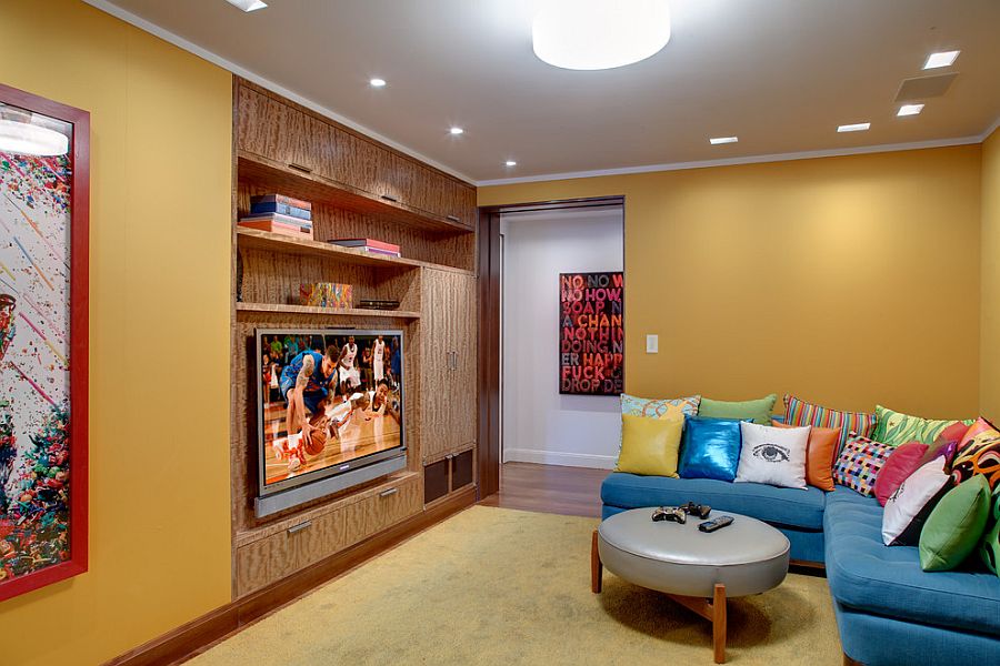 Bright L-shaped couch in blue with colorful accent pillows for the TV room [Design: InnerSpace Electronics]