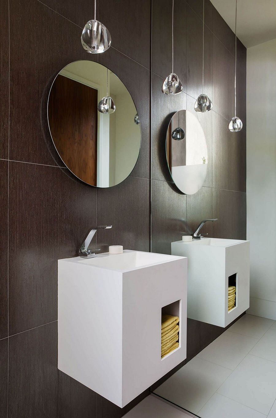Circular mirrors and stunning pendant lights inside contemporary bathroom in gray