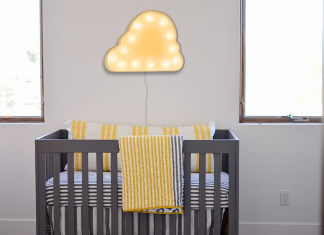 Cloud-shaped marquee sign hung above crib