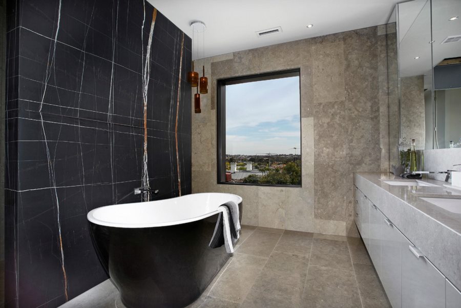 Curved tub in a bathroom with a black marble wall