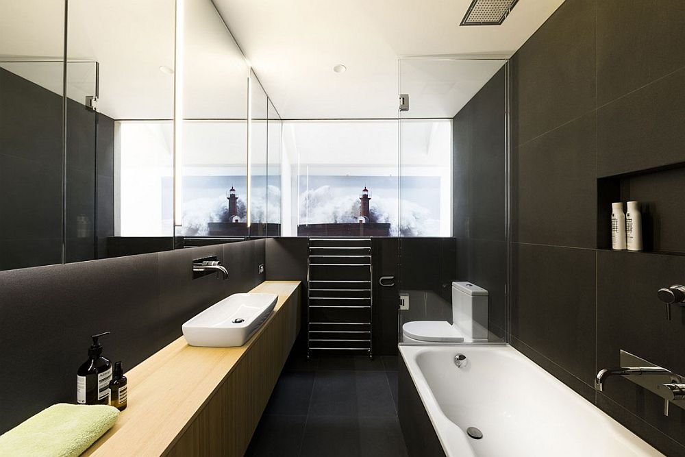 Dark bluestone creates a sophisticated backdrop for the relaxing bathroom