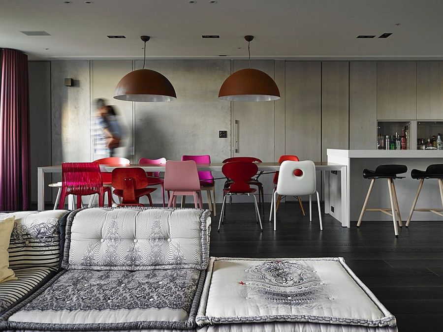 Dining room with large industrial pendants and colorful chairs