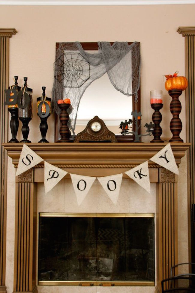 Fireplace mantel with spooky candlesticks and banner