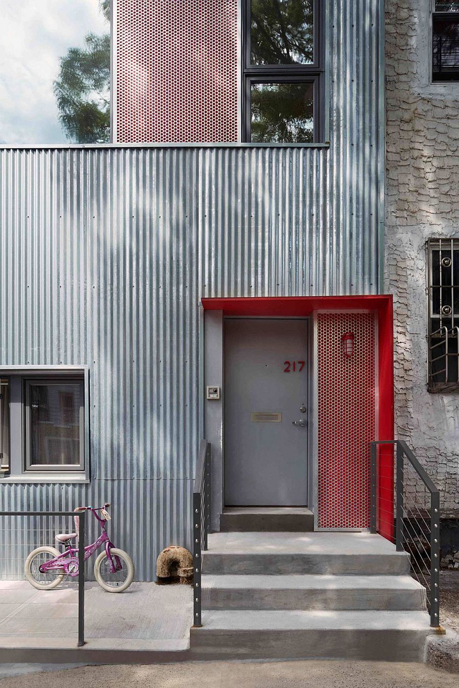 Framed red accent panels in perforated aluminum add color and texture