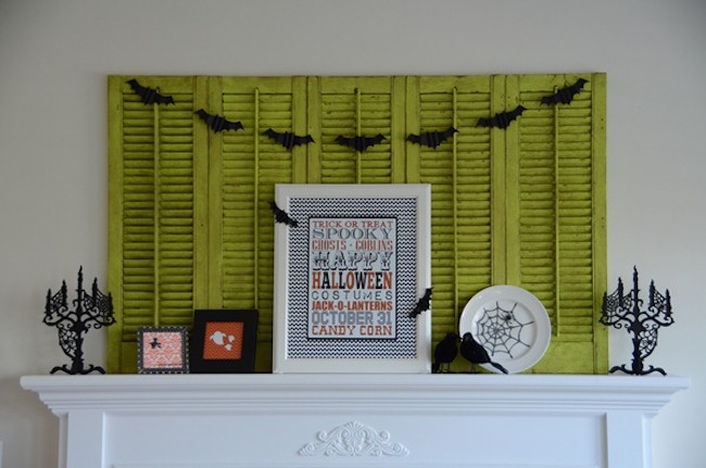 Halloween decorations paired with weathered green shutters on a mantel