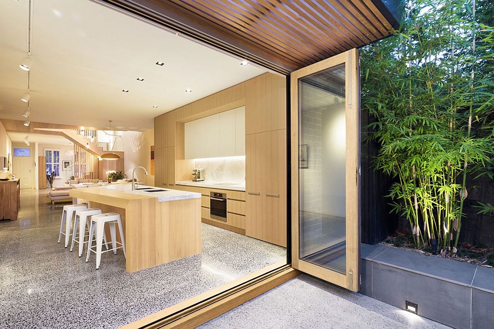 Kitchen island in wood and stone with breakfast zone and wooden shelves