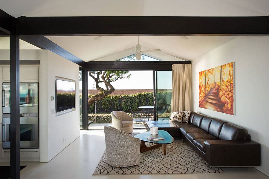 Living area of the revamped LA home connected with the extreior landscape through glass doors