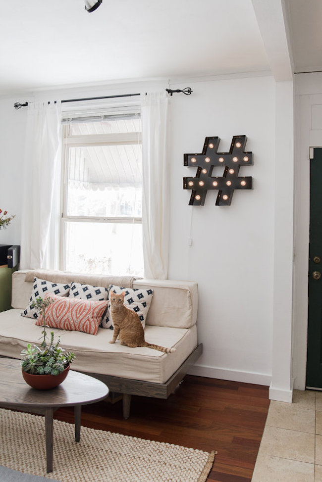 Pound sign-shaped marquee light hung in a living room