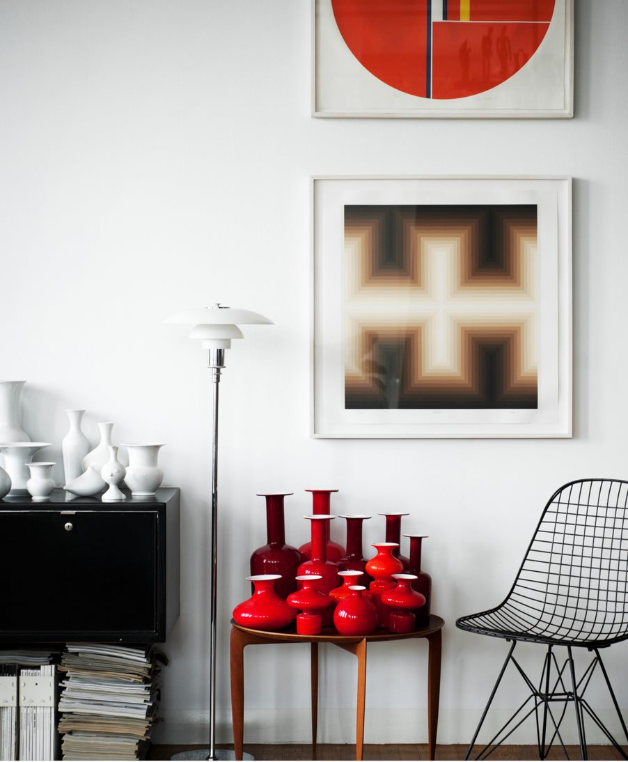 Red vases in a room by Kit Republic