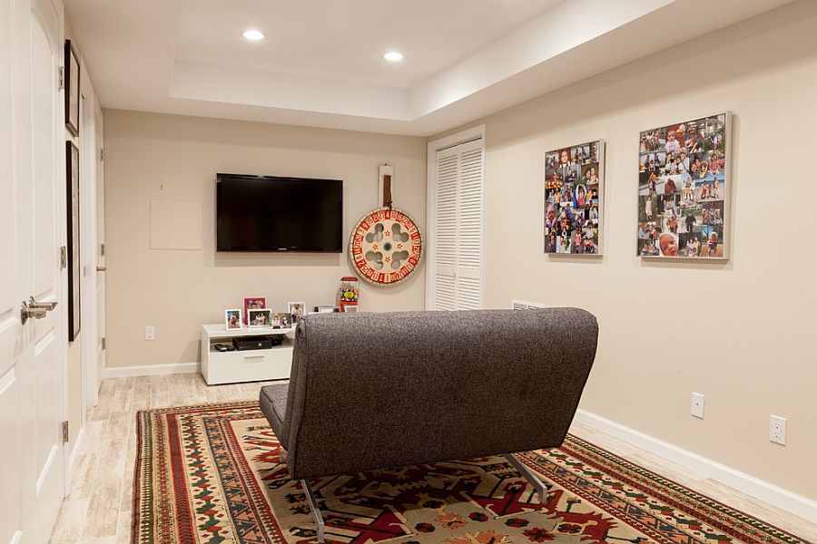 Small basement TV room with a lovely rug and a small sofa [Design: Simply Baths & Kitchens]