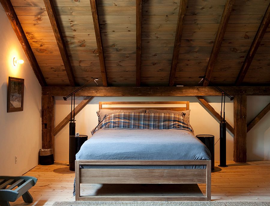 Stained wooden slanted ceiling adds to the rustic charm of the cozy bedroom