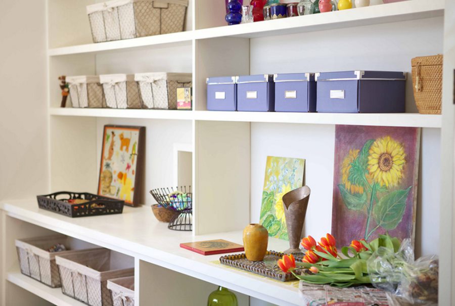 Vases and baskets of supplies on a large bookshelf