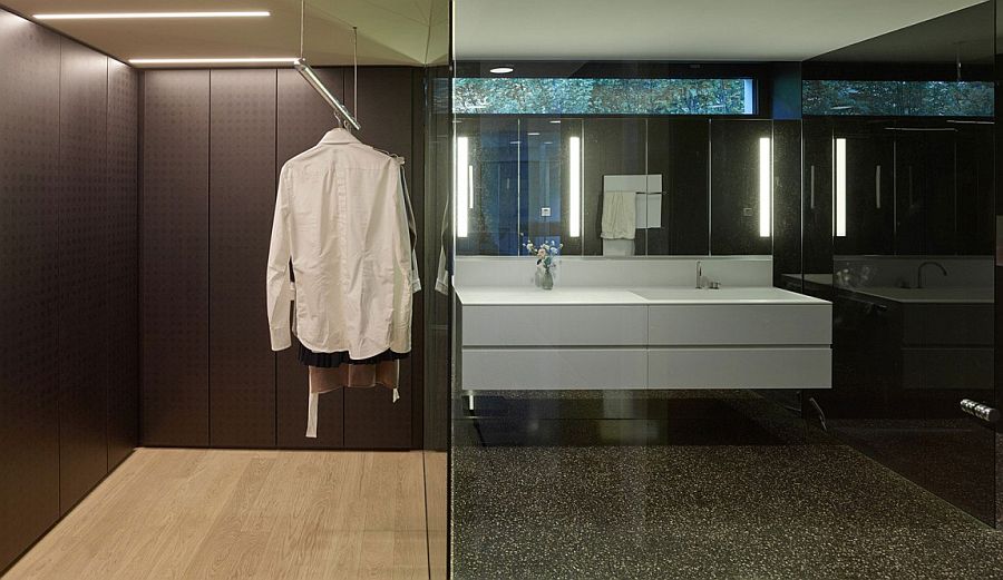 Walk-in closet and contemporary bathroom in dark stone