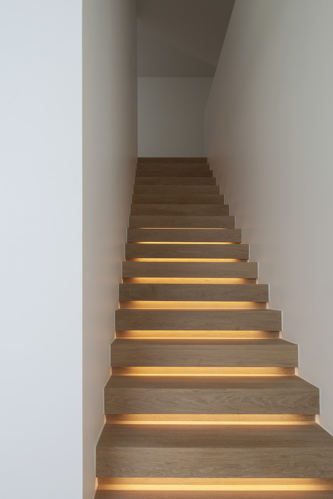 Wood staircase with lighting that creates a soft glow