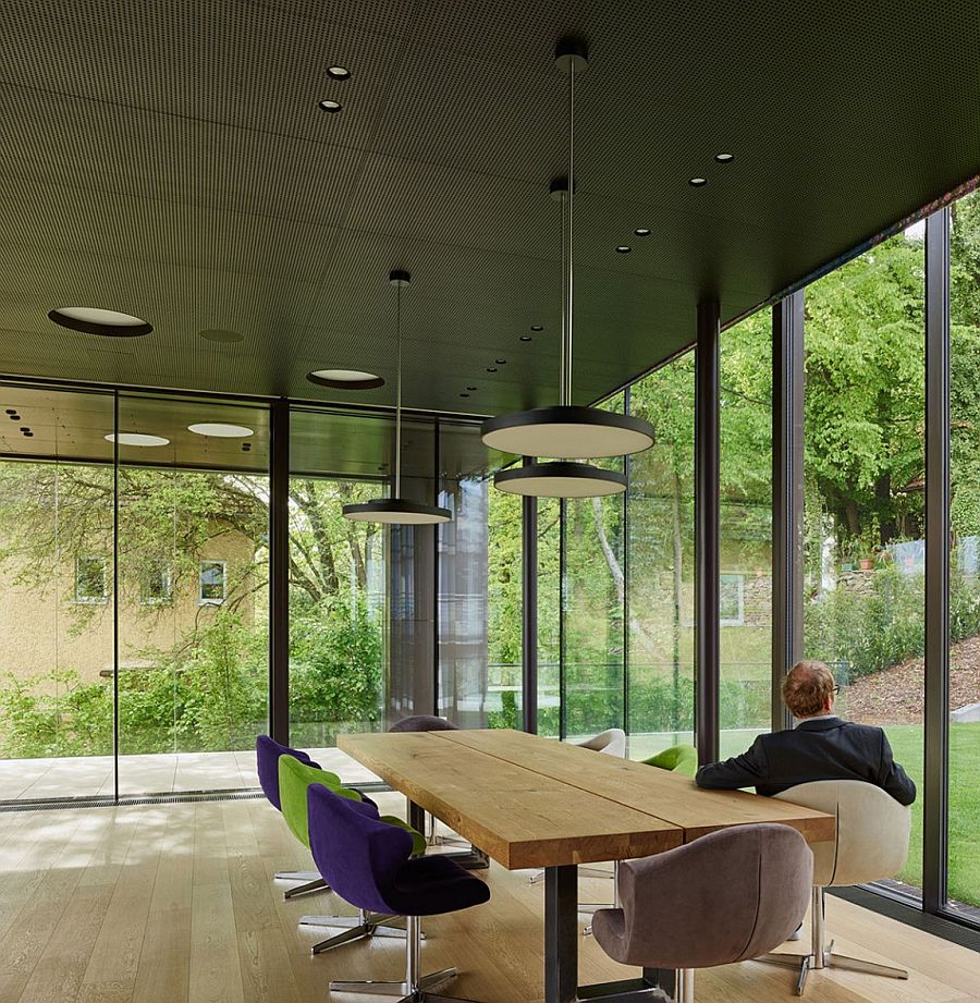 Wooden top dining table with metal legs and colorful chairs around it