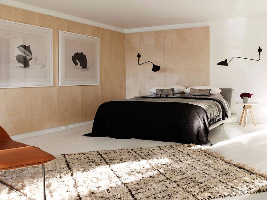 Wooden walls with large black and white framed picures in the bedroom