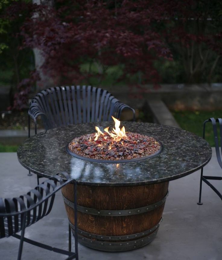 A fire burns in an old wine barrel repurposed as a fire pit