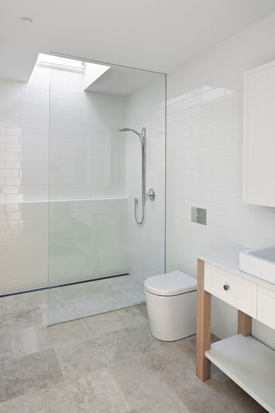 All-white bathroom with glass shower area and skylight