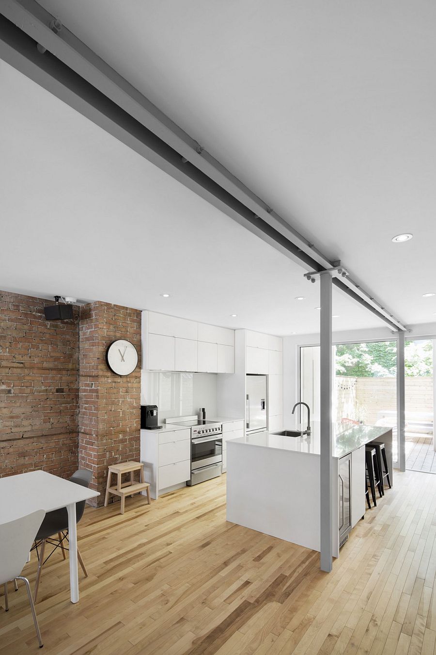 Contemporary kitchen of the home sits next to the exposed brick wall