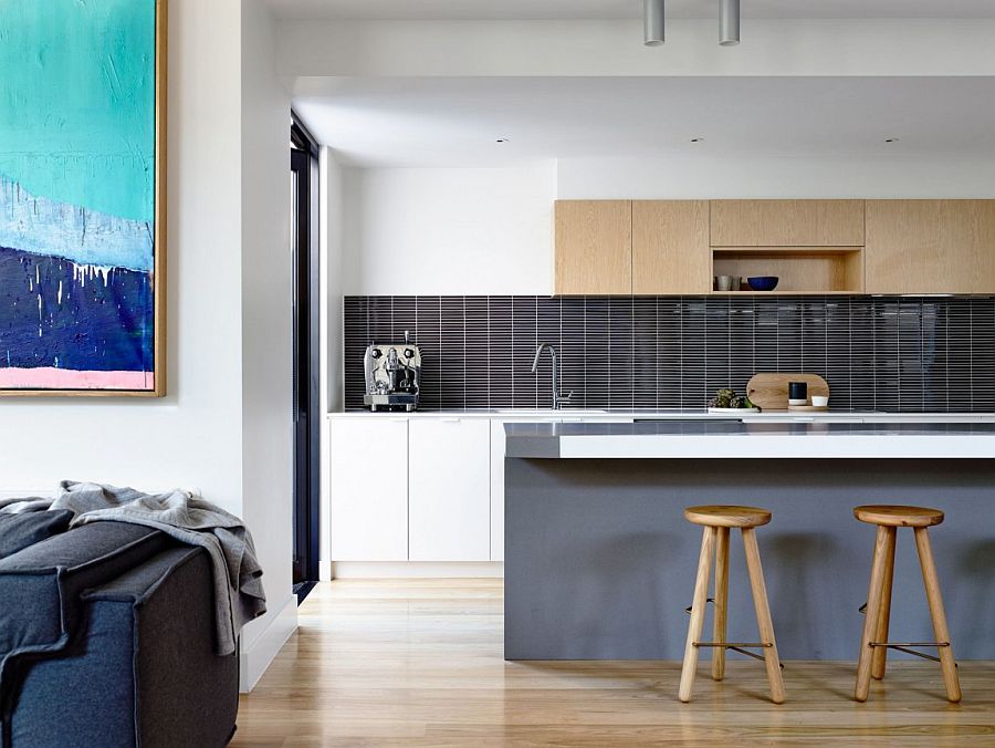 Contemporary kitchen with a gray island and a sparkling backsplash