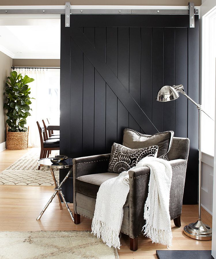 Dark black barn door fits in with the contemporary theme of the living room seamlessly