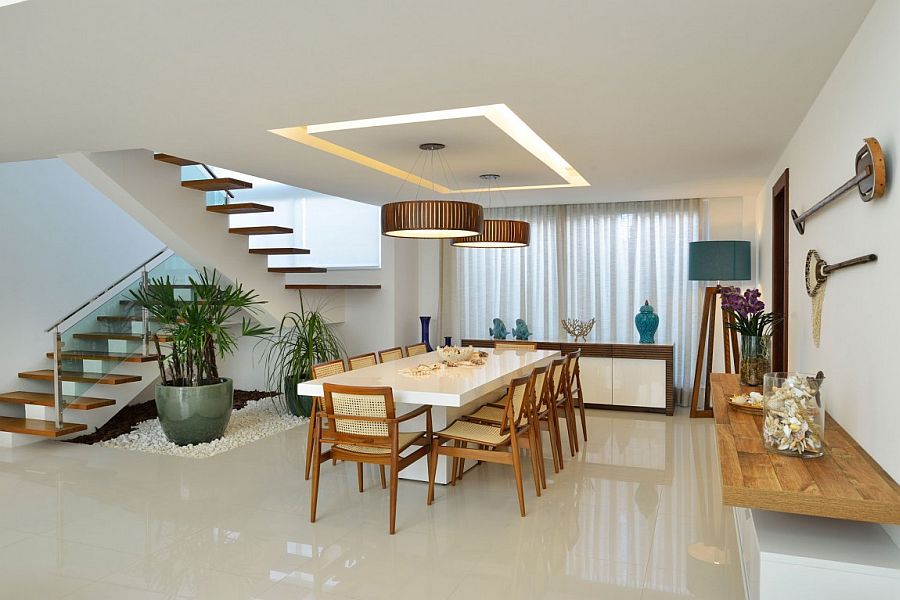 Dining room with sleek floating shelf, oversized floor lamp and brilliant pendant lighting