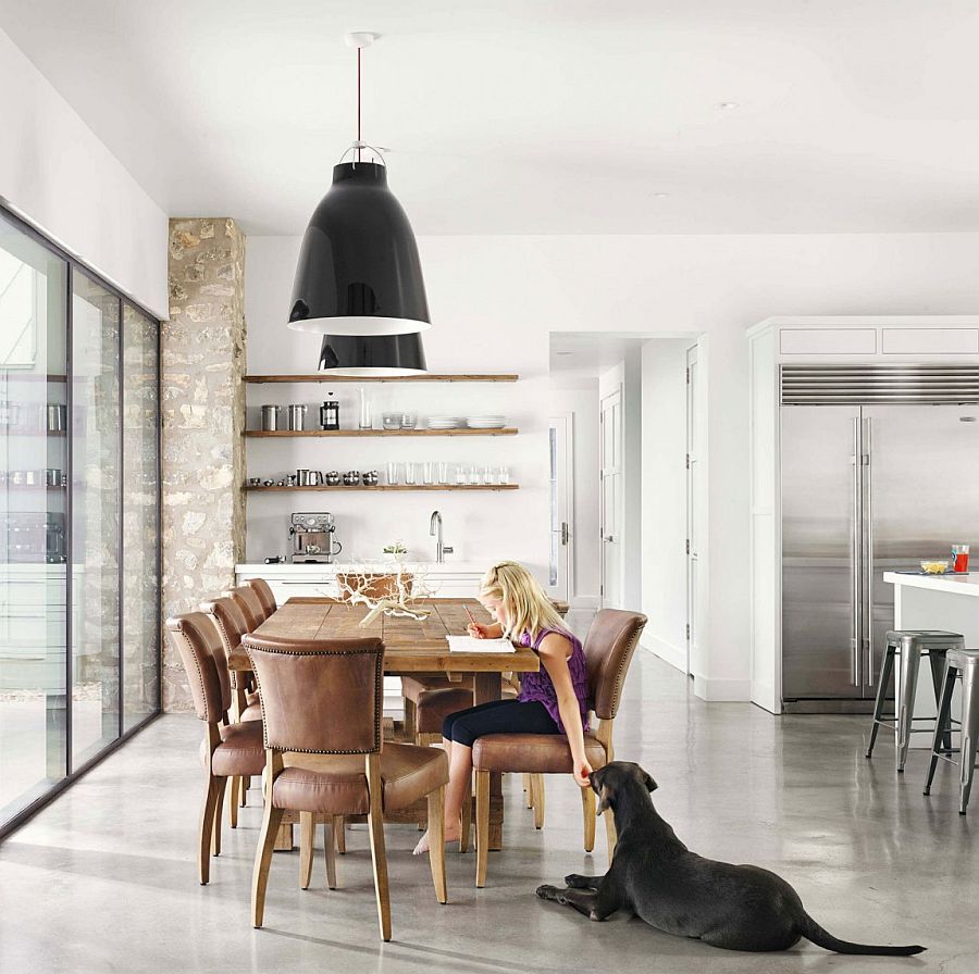 Dining space with open shelves in wood, large pendants and a wooden dining table