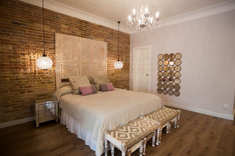 Exposed brick wall and glamorous lighting in the chic bedroom [Design: Pia Capdevila]