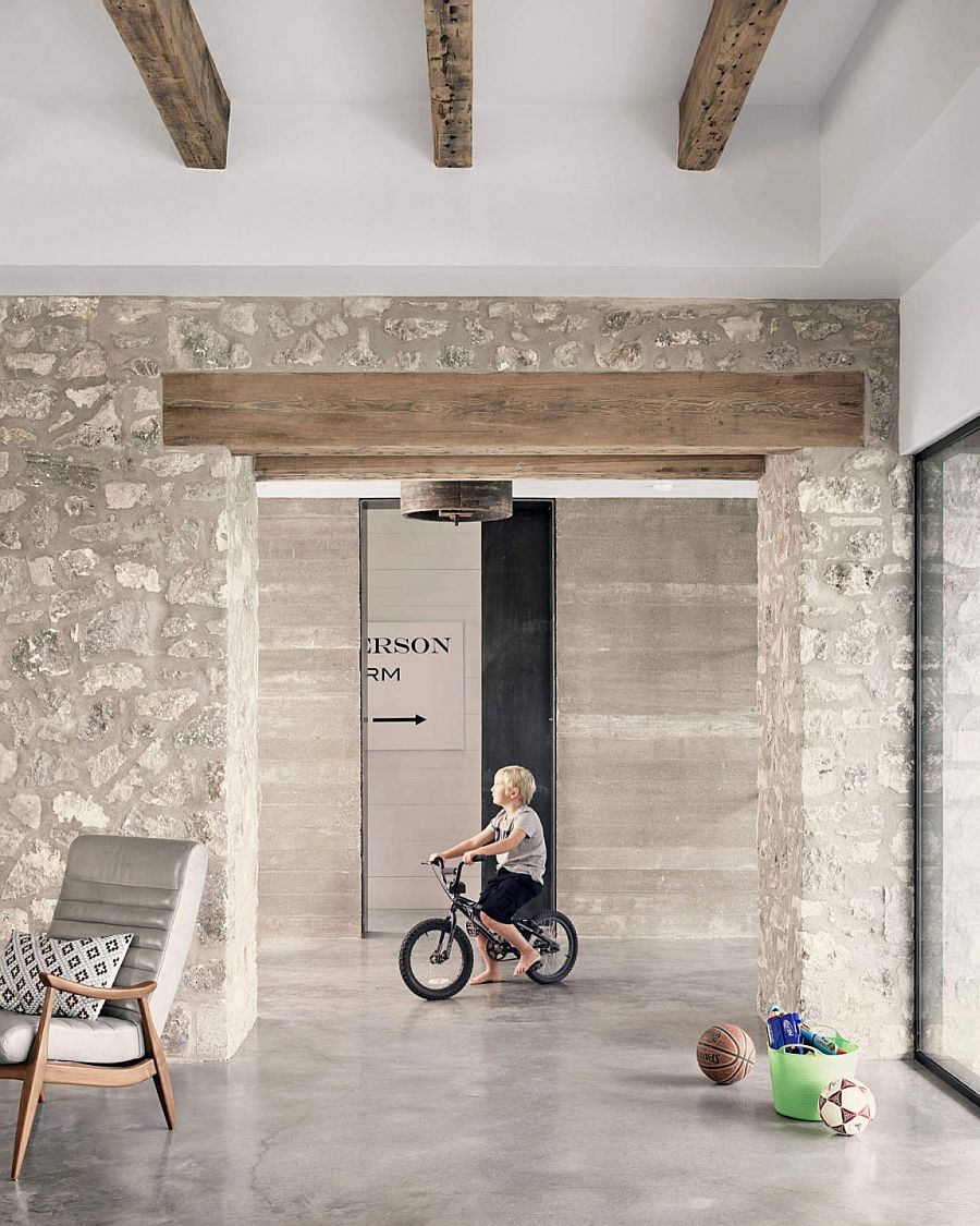 Exposed wooden beams and stone walls shape the interior of the modern home