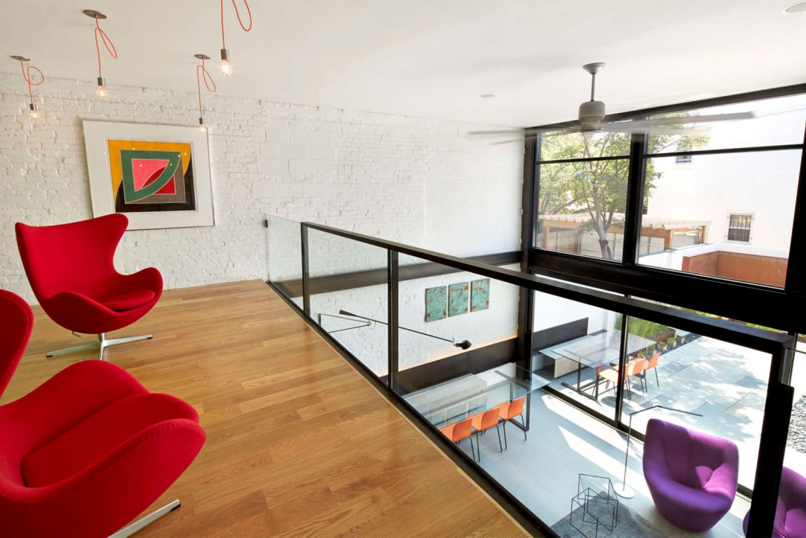 Gorgeous reading zone on the mezzanine level with simple lighting and colorful wallart