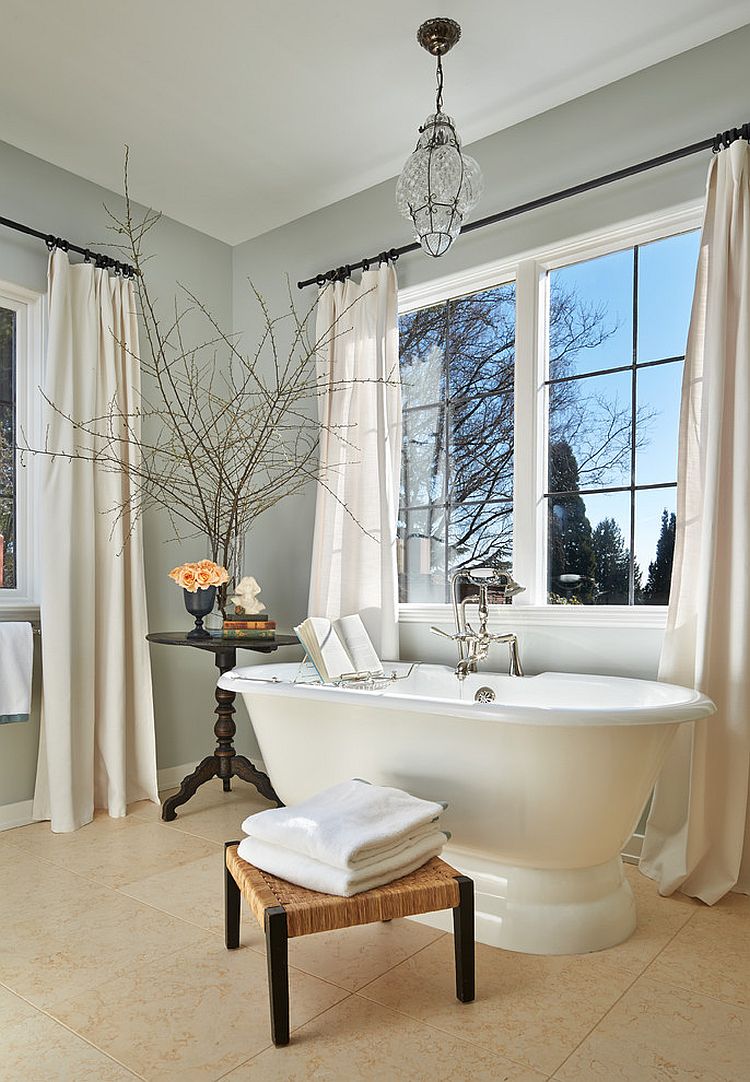 Gray and white bathroom with classic freestanding bathtib, footstool and side table