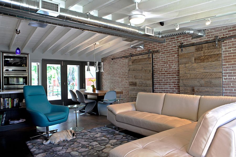 Industrial living room with brick wall and sliding barn doors [Design: The Ranch Mine]