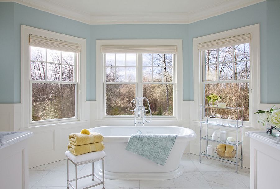 Light blue and white bathroom with sleek stool next to the bathtub