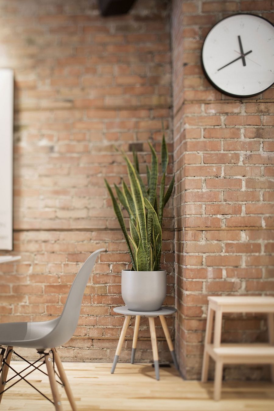 Modern decor sits in the living room with brick wall background