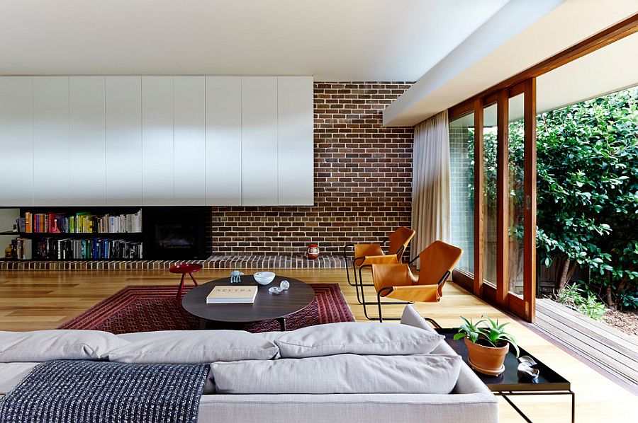 Modern living room mixes brick wall with contemporary shelves in white