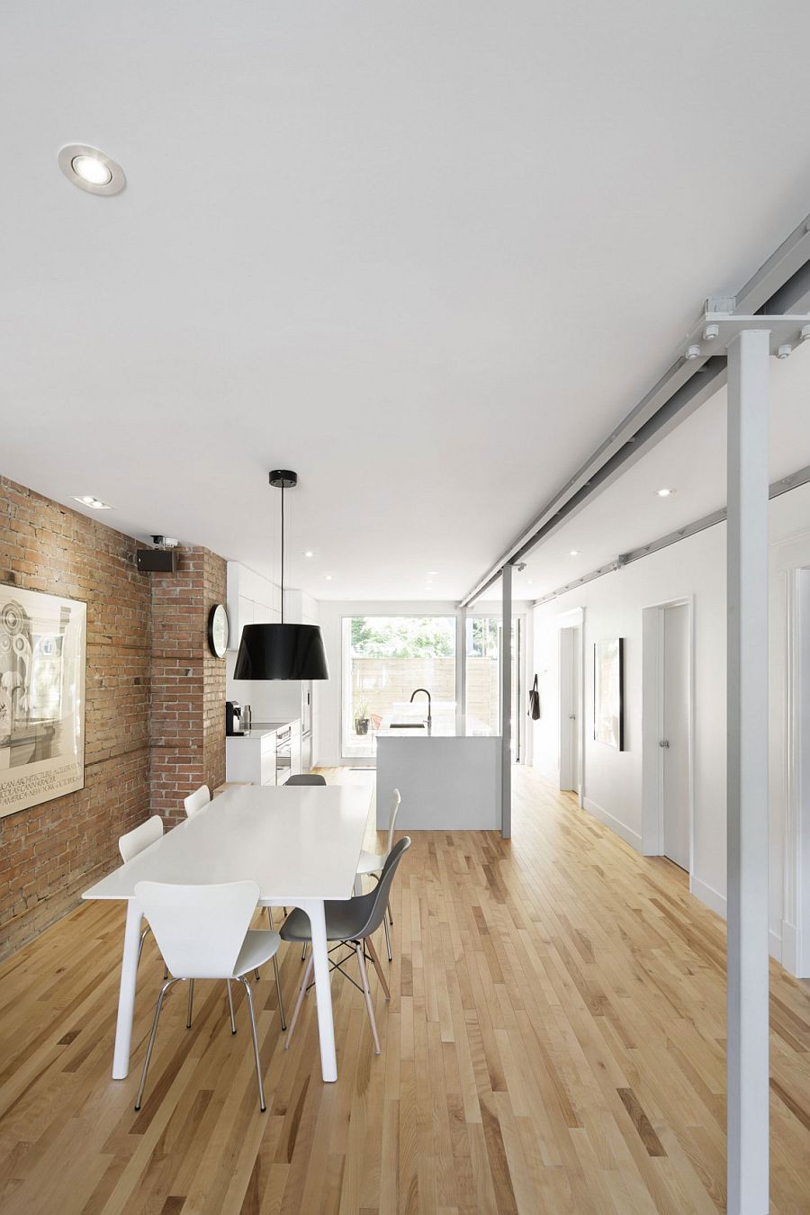 Natural birch flooring and exposed brick wall give the interior a cozy vibe