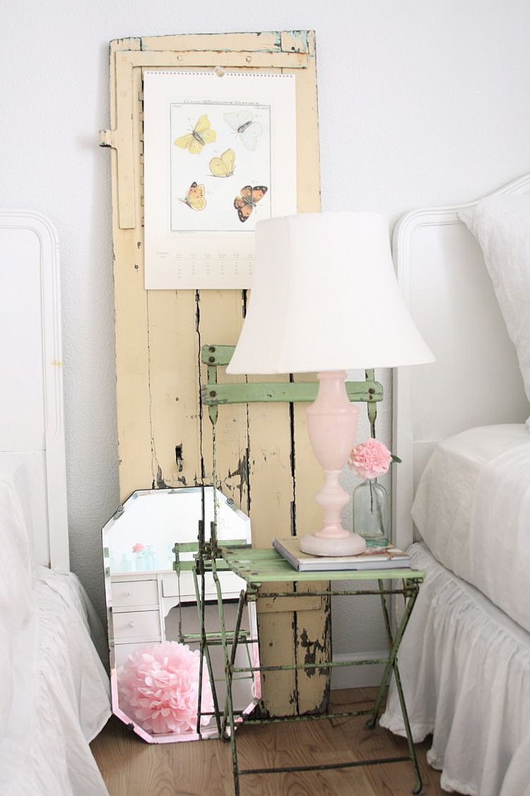 Old chair, vintage door and lovely lamp make the bedside area a shabby chic delight