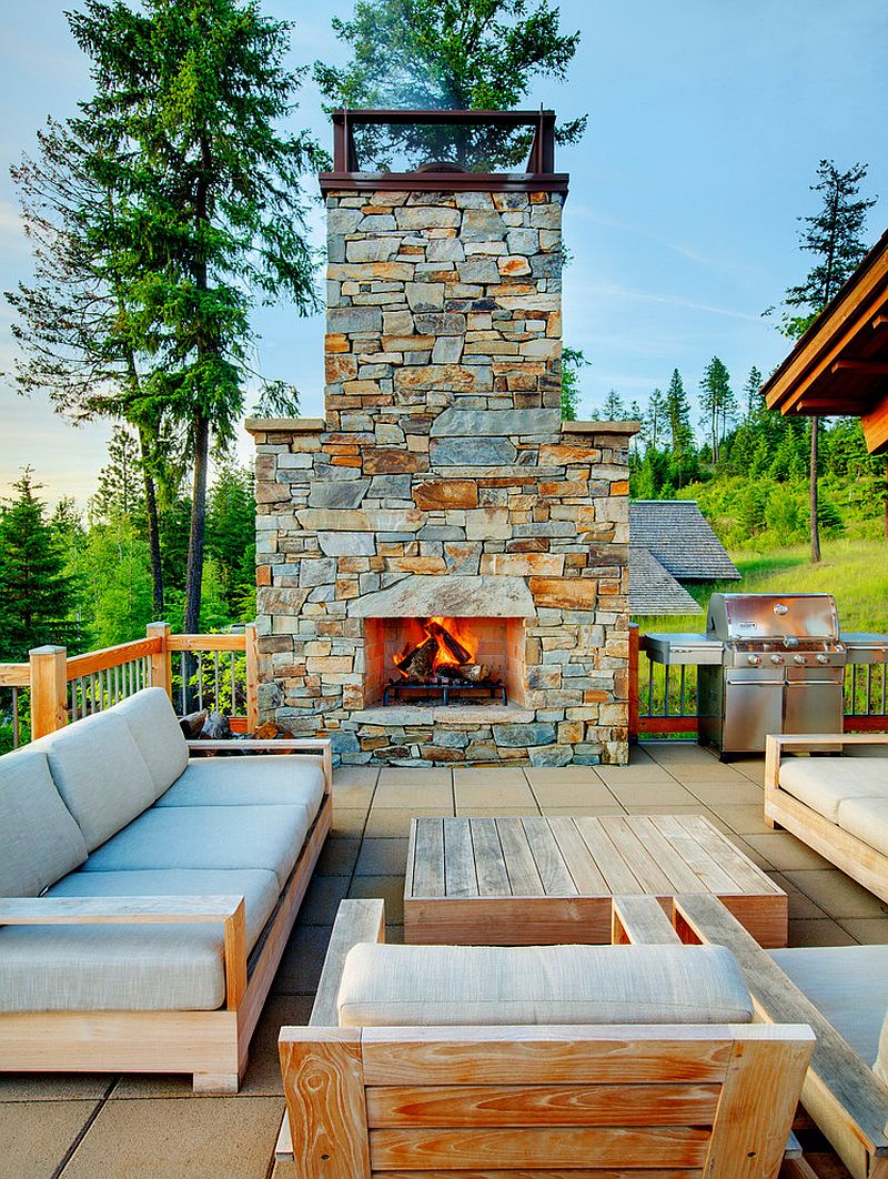 Open deck design with plush furniture and cool stone fireplace