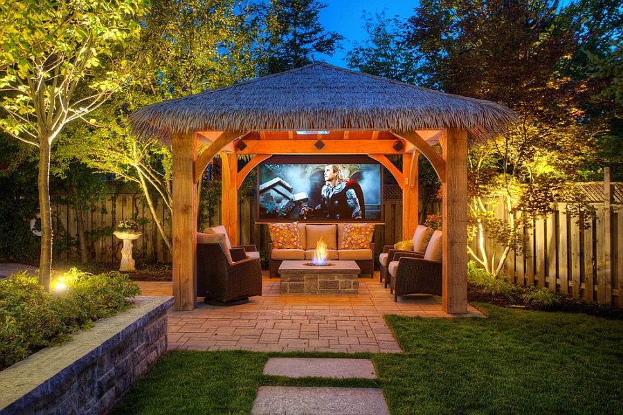 Patio with tropical style hut that is the perfect for outdoor movie night [Design: Cedar Springs Landscape Group]