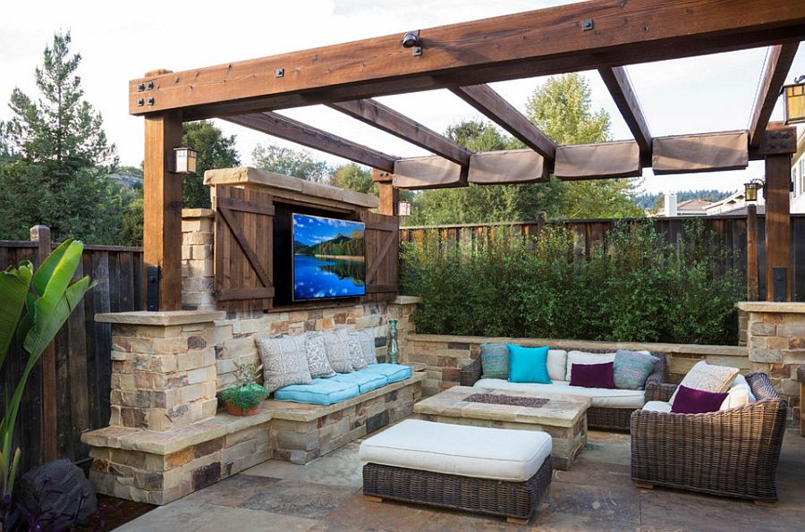 Pergola with outdoor TV, fireplace and cozy seating [Design: West Bay Landscape]