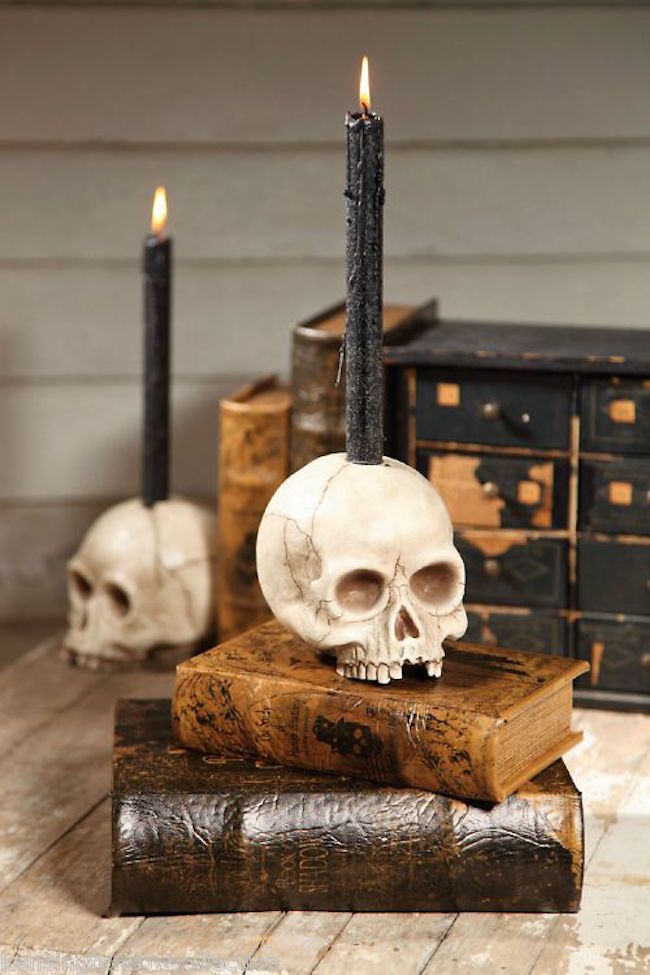 Realistic skull candle holder with black taper candle
