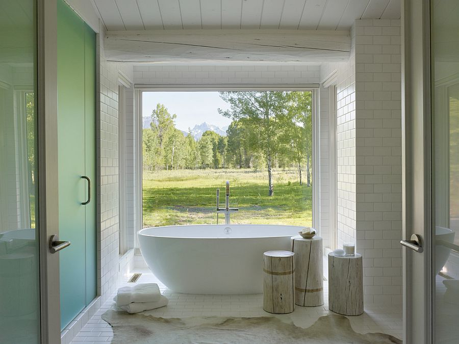 Rustic bathroom with large window connecting it with the outdoors [Design: Carney Logan Burke Architects]