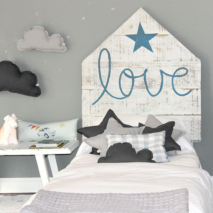 Rustic headboard and cloud-shaped pillows in a kids' bedroom